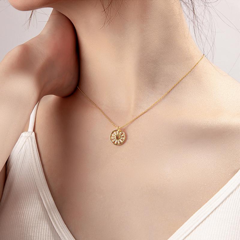 Collier pendentif rond en or avec une fleur de diamants porté par une femme sur un fond neutre. élégance et simplicité.