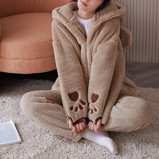 Ensemble pyjama polaire pauline confortable pour l'hiver avec capuche et motifs pattes, idéal pour se détendre à la maison.