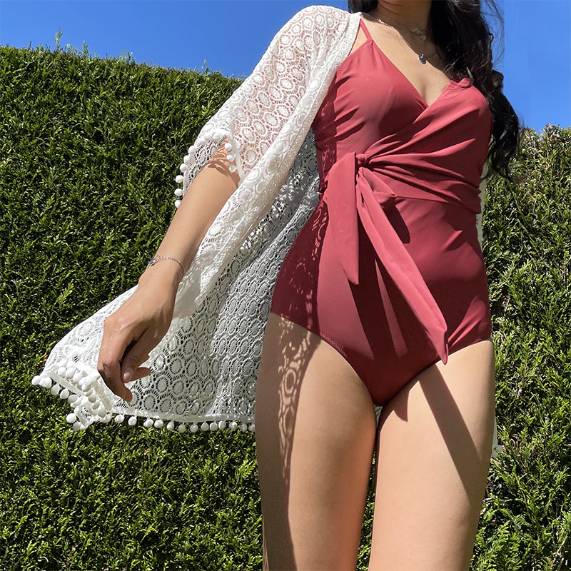 maillot de bain rouge une pièce avec ceinture nouée et kimono en dentelle blanche porté en extérieur sous le soleil