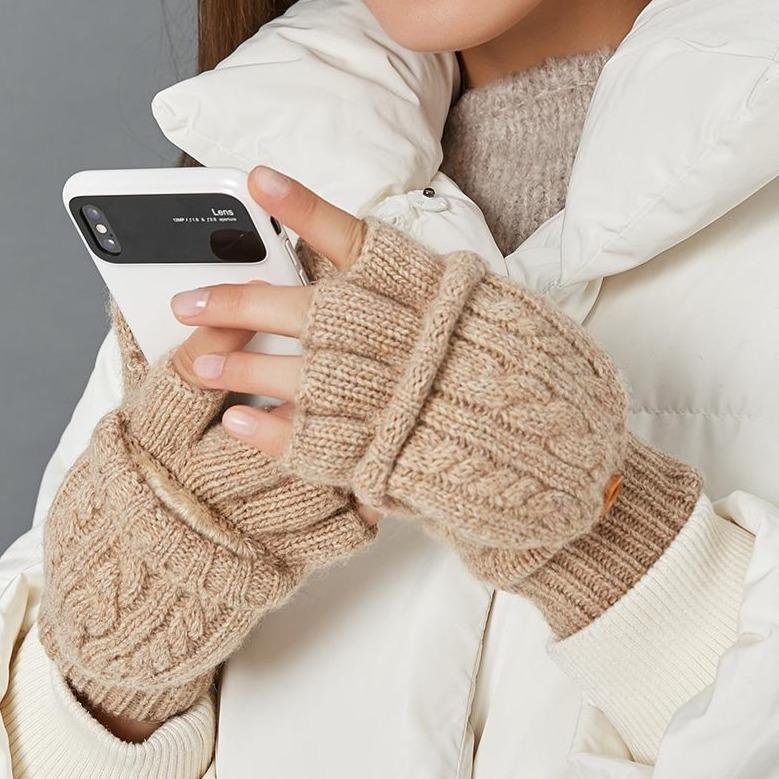 moufles mitaines laine beige pour femme utilisant un smartphone en hiver avec une veste blanche et un pull beige