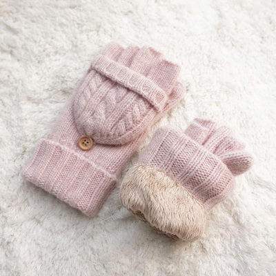 moufles mitaines en laine rose posées sur une surface moelleuse, idéales pour garder les mains au chaud en hiver