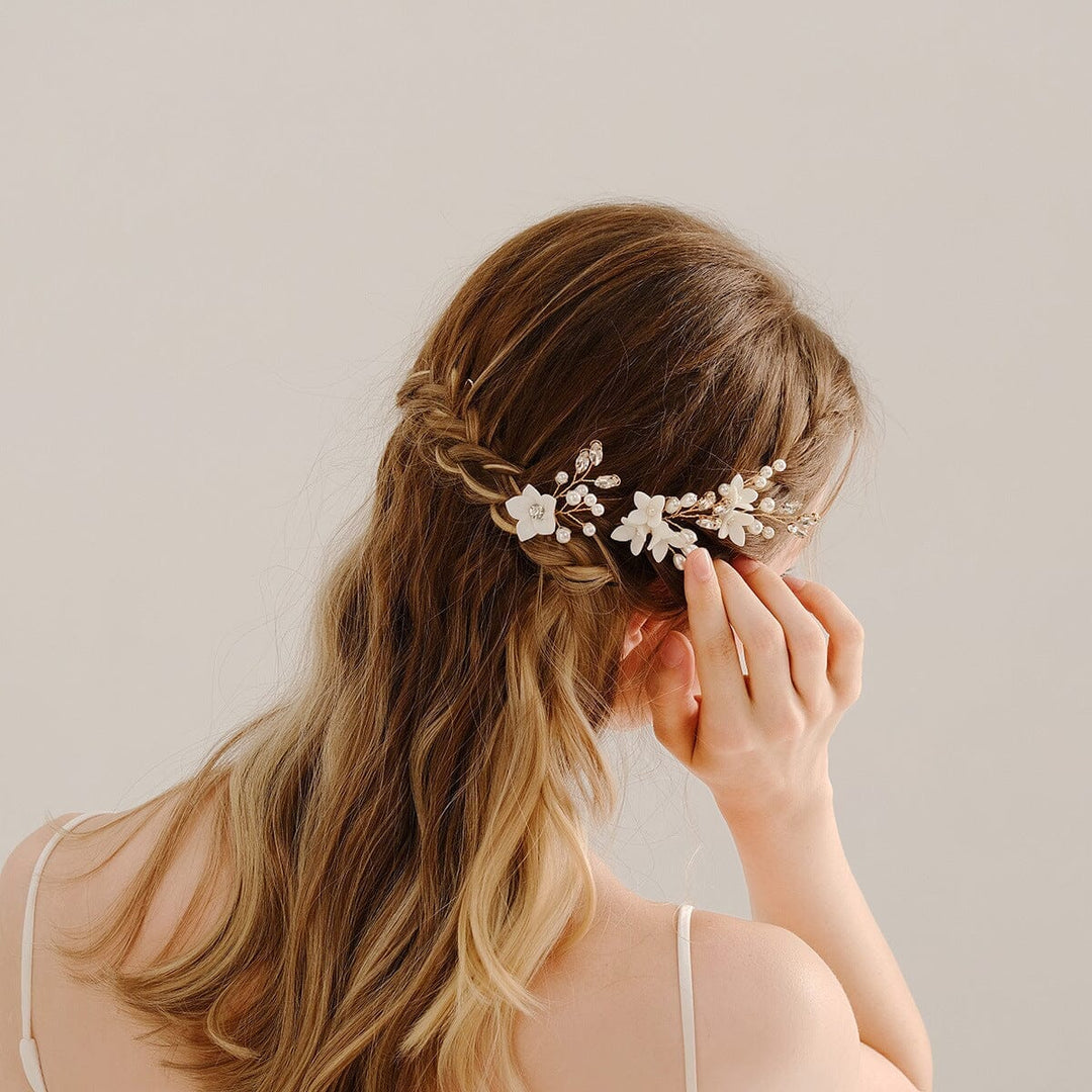 pince cheveux mariage artisanale ornée de fleurs blanches portée par une femme avec une coiffure tressée élégante