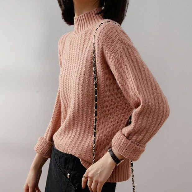 pull maille torsadée rose pour femme avec col montant et manches longues, modèle noémie, porté avec un pantalon noir