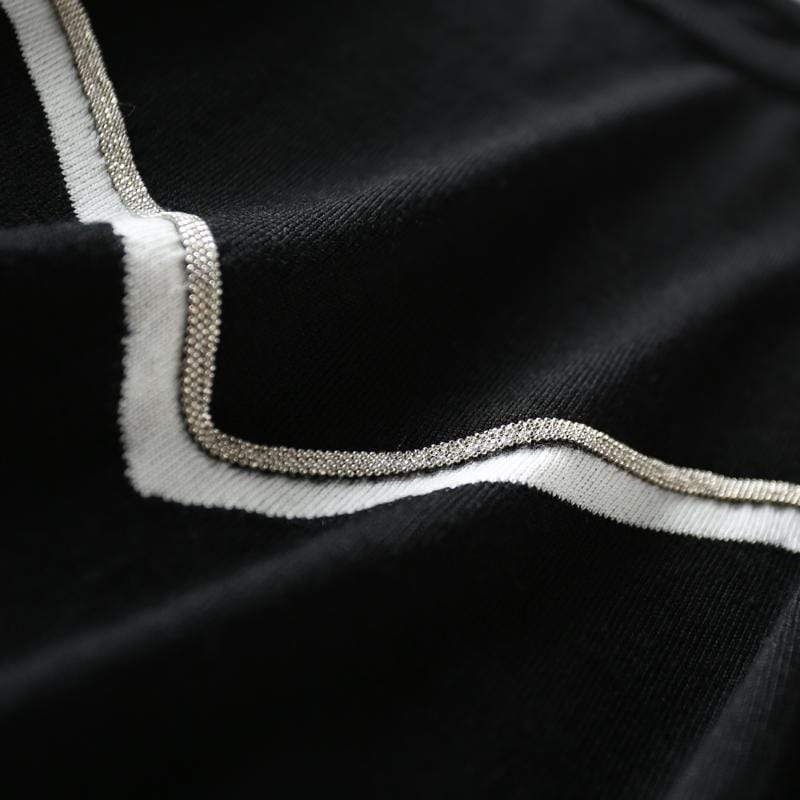 détail de la texture du pull noir manches courtes victory en fibre écologique avec bordure blanche et argentée