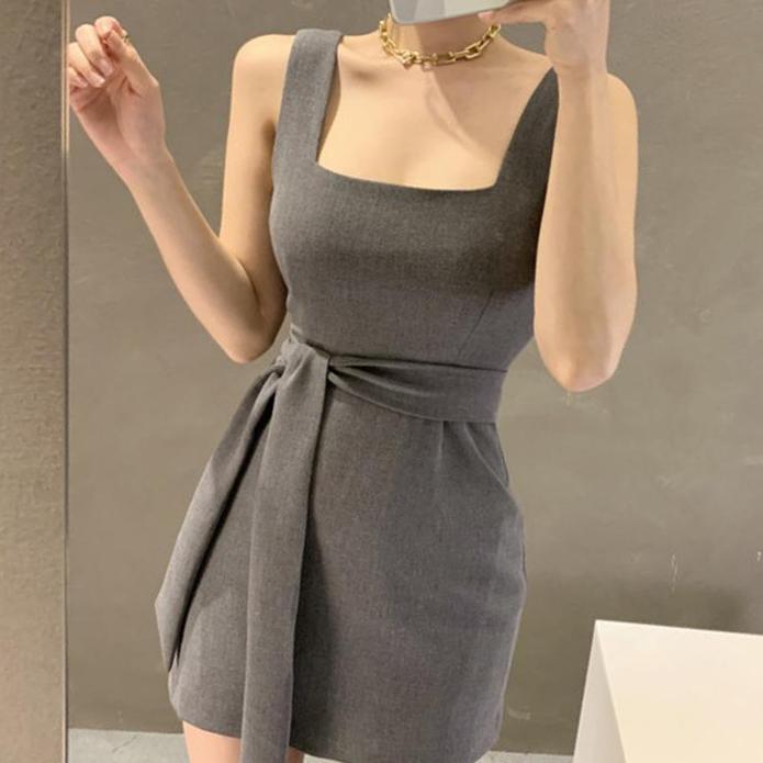 robe courte chic grise avec ceinture portée par une femme moderne, idéale pour des occasions spéciales ou sorties en soirée