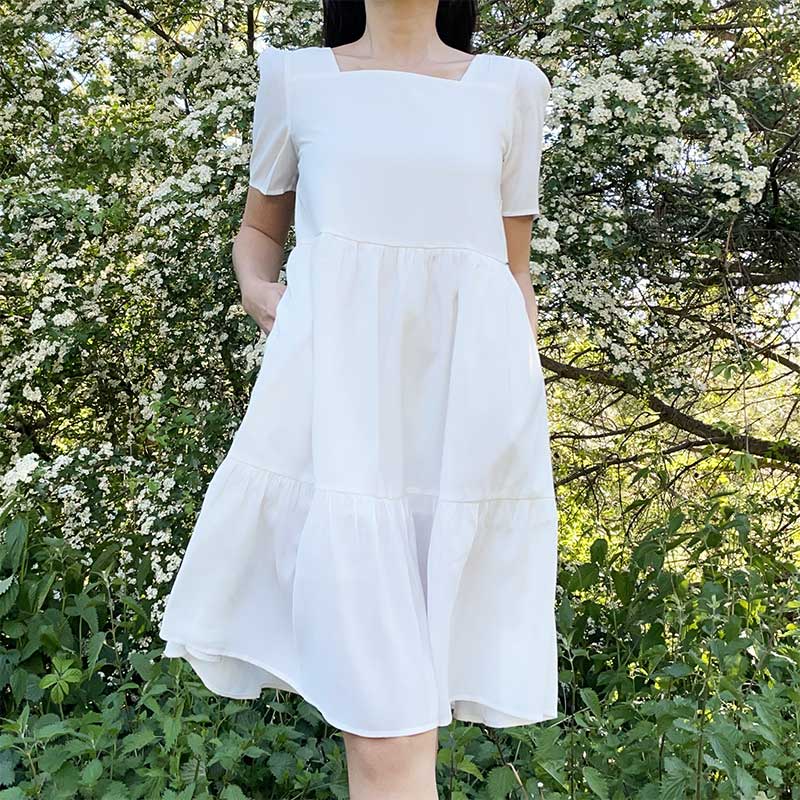 femme portant une robe bohème blanche charlotte en pleine nature, coupe évasée, idéale pour un style léger et élégant