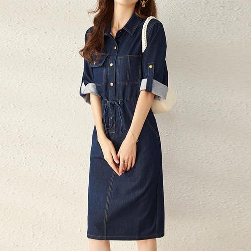 robe en jean mi-longue avec poches, manches retroussées et ceinture, portée par une femme, parfaite pour un style décontracté