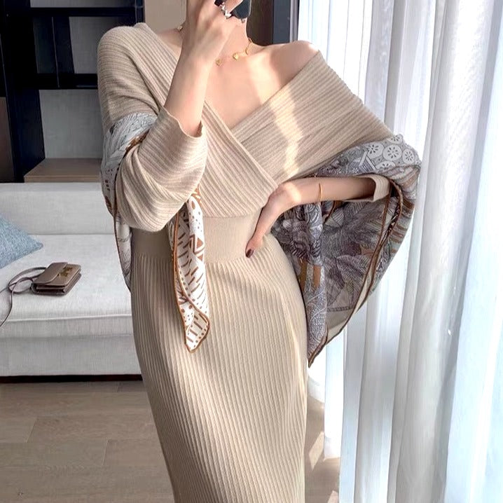 femme portant une robe longue en maille beige avec manches évasées et un foulard imprimé, posant dans un intérieur moderne