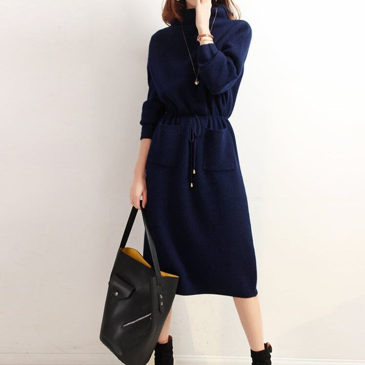 femme portant une robe col roulé bleue avec une taille cintrée et manches longues, tenue élégante avec sac noir