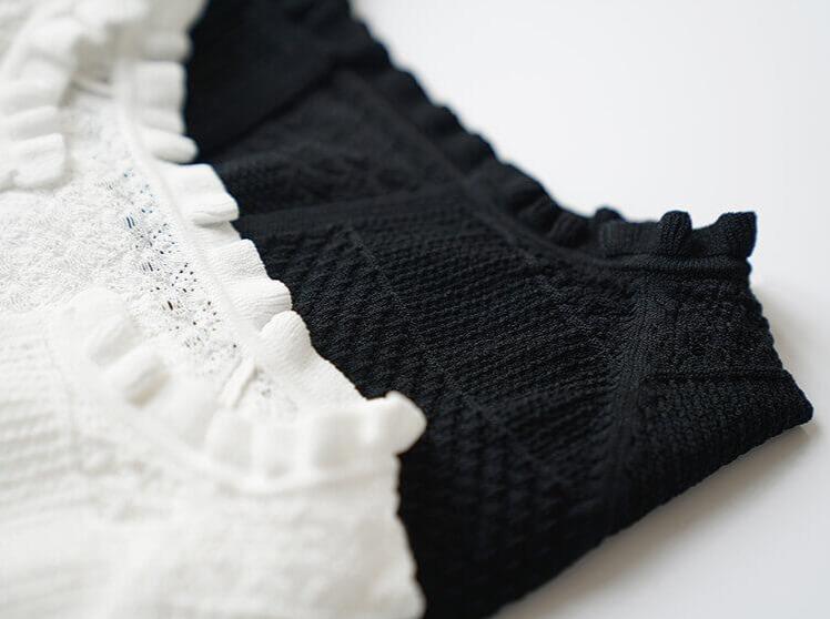 top crochet femme Nathan blanc et noir en tricot, gros plan sur les détails de dentelle et motifs texturés