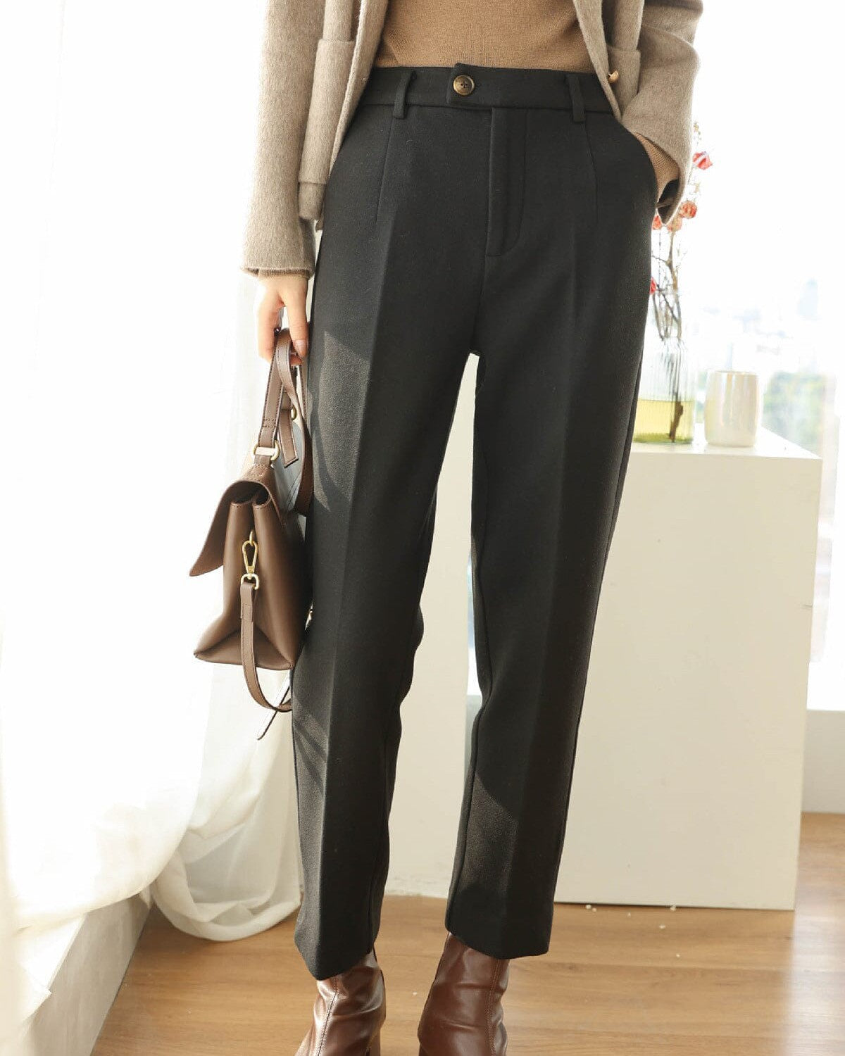 pantalon tailleur chic noir pour femme avec sac marron et bottes en cuir, look élégant et moderne pour bureau